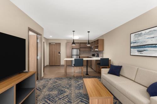 a living room with a couch and a table at Candlewood Suites Huntsville - Research Park by IHG in Huntsville