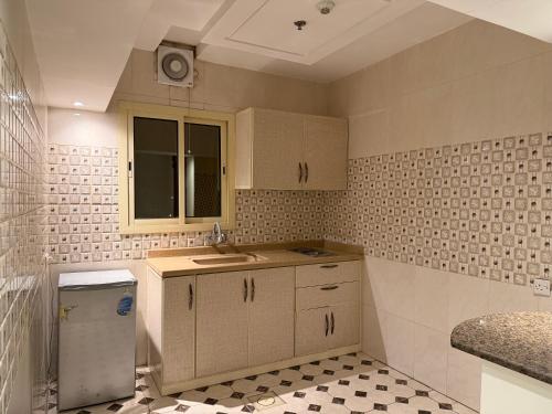 a kitchen with white cabinets and a sink and a window at فندق قصر الخضراء بارك اشبيليا in Riyadh