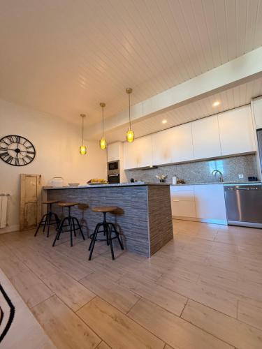 a kitchen with a counter and stools in a room at Casa Do Cruzeiro Apartment in Armamar