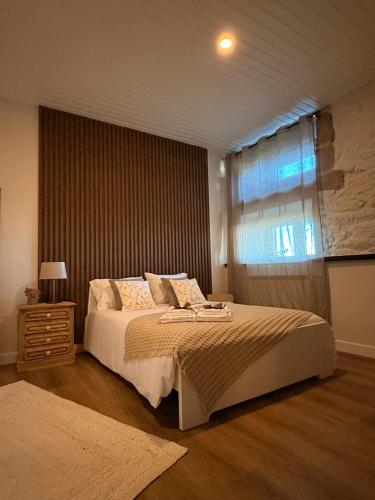 Un dormitorio con una cama grande y una ventana. en Casa Do Cruzeiro Apartment, en Armamar