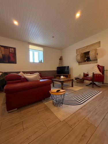 a living room with a red couch and a table at Casa Do Cruzeiro Apartment in Armamar