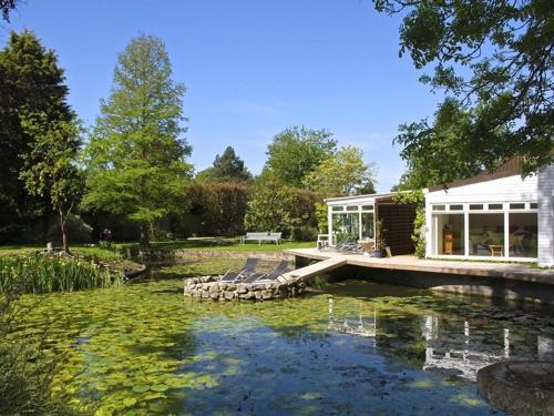 a house with a deck and chairs in the water at TOR Rooms in Canterbury
