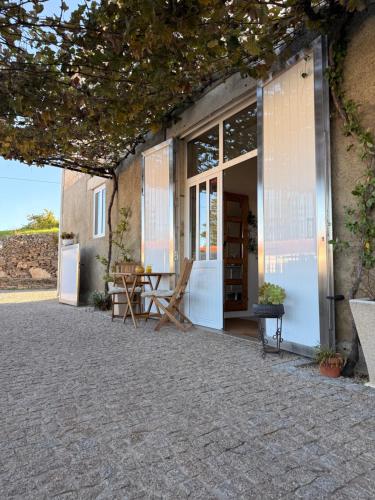 a patio with a table in front of a building at Casa Do Cruzeiro Apartment in Armamar