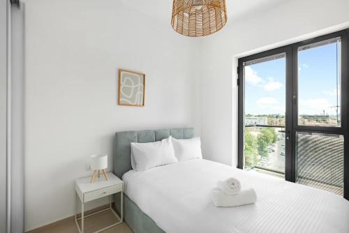a white bedroom with a bed and a window at Oַ&O Group- Luxury Tower 3BR Beach View High Floor in Bat Yam