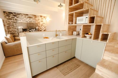 a kitchen with a sink and a microwave at Maison cosy avec terrasse, à 5 minutes des plages in Porspoder