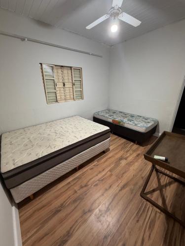 a bedroom with two beds and a ceiling fan at Chácara Barbosa in Rio Claro