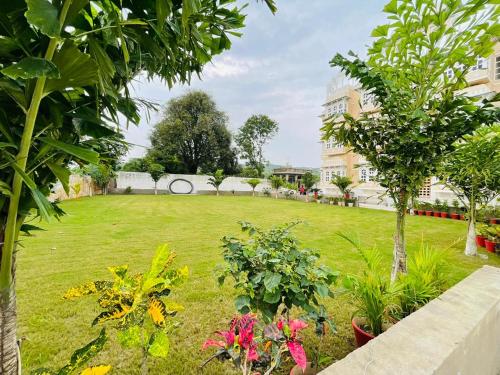 a garden with flowers and trees and a building at Aryavarta A Boutique Abode in Nāi