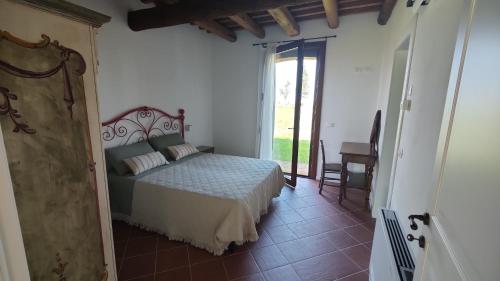 Un dormitorio con una cama y una puerta corrediza de vidrio. en Agriturismo Villa Luisa, 