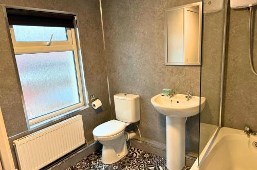 a bathroom with a toilet and a sink at Fully Furnished 3 Bedroom House in Preston with Free Parking in Preston