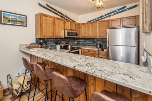 a kitchen with wooden cabinets and a stainless steel refrigerator at Snowflake at Skycrest in Big Sky