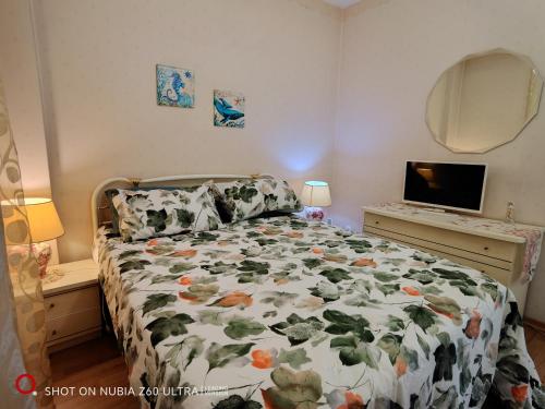 una camera da letto con un letto con un piumone floreale di Atlantis Apartment Trieste a Trieste