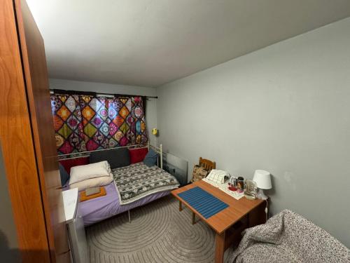 a small room with a bed and a table at Unikal in Grorud