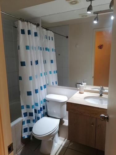 a bathroom with a toilet and a sink and a shower curtain at Vista velero in Algarrobo