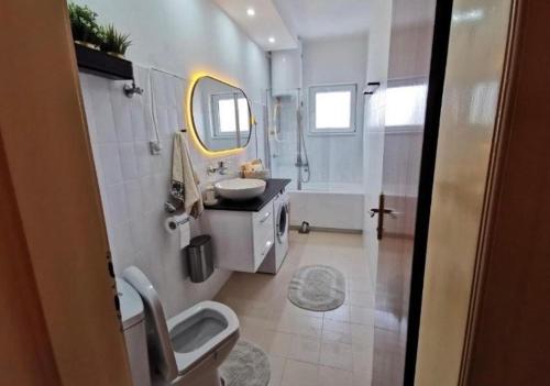 um banheiro branco com uma pia e um espelho em Vila Miona Apartments em Belgrado