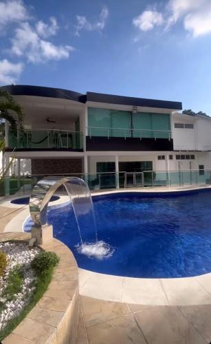 a swimming pool with a fountain in front of a building at Villa Cami in La Mata