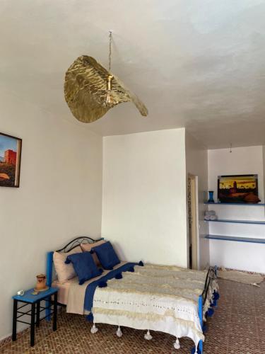 a bedroom with a bed and a ceiling fan at Maison D'hôtes Ait Mouli in Bzou