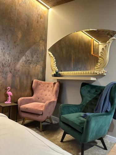a bedroom with two chairs and a mirror at Hugo Airport in Mārupe