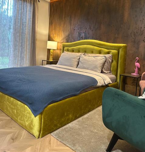 a bedroom with a large bed with a green headboard at Hugo Airport in Mārupe