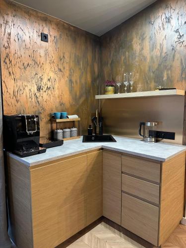 eine Küche mit Holzschränken und einer Arbeitsplatte in der Unterkunft Hugo Airport in Mārupe