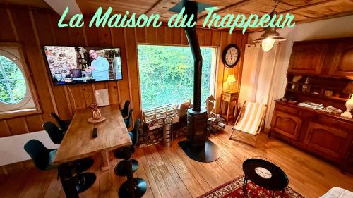 a living room with a woodburning stove and a table at La maison du Trappeur et la cabane des sources in Le Mont-Dore