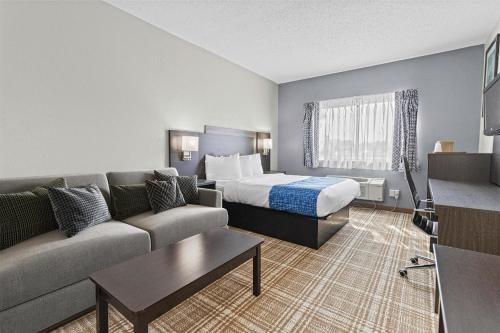 ミノクアにあるGrandStay Hotel & Suites Minocquaのベッドとソファのあるホテルの部屋