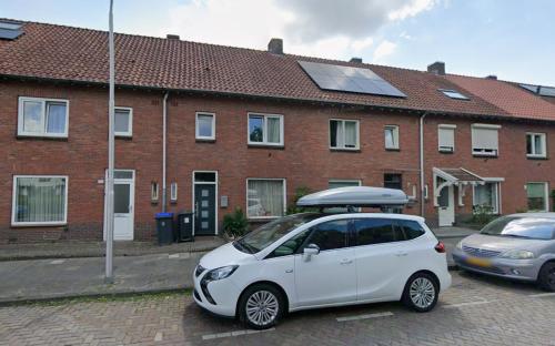 a white smart car parked in front of a brick building at Beethoven Homestay in Eindhoven