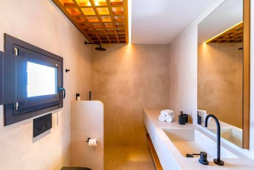 a living room with a tv and a refrigerator at 180 Suites in Imerovigli