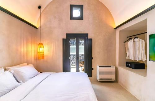 a bedroom with a white bed and a window at 180 Suites in Imerovigli