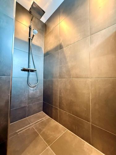 a bathroom with a shower with a tile wall at Waldeck in Wadgassen