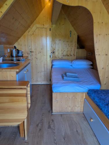 a small bedroom with a bed and a sink at Macbeth's Hillock in Forres