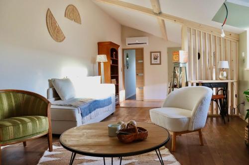 a living room with a bed and a coffee table at Le Hameau des Bruyères in Cercié