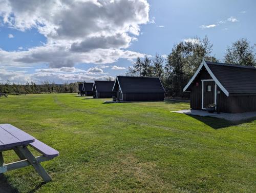 a row of tents in a field with a picnic table at Macbeth's Hillock in Forres