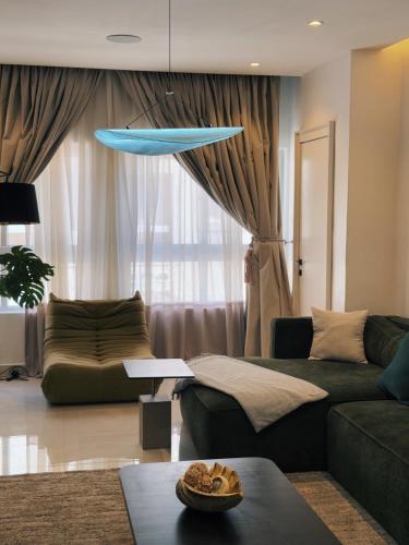 een woonkamer met een groene bank en een blauw surfplank bij Peartree Homes in Lagos