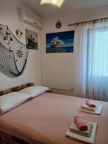 a bedroom with a bed with two towels on it at Rooms Tia in Baška Voda