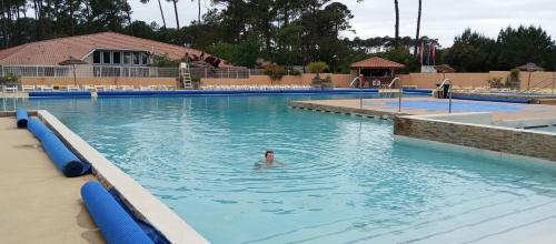 a man swimming in a swimming pool at Superbe mobil-home à Seignosse plage in Seignosse