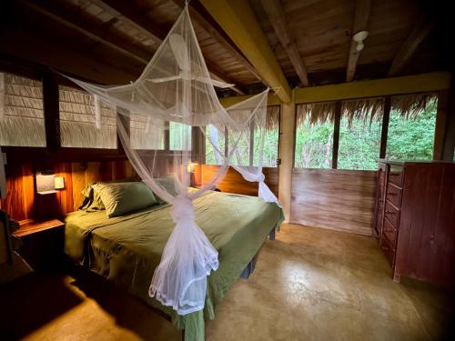 a bedroom with a bed with a mosquito net at Cabaña DREAM HOUSE in San Agustinillo