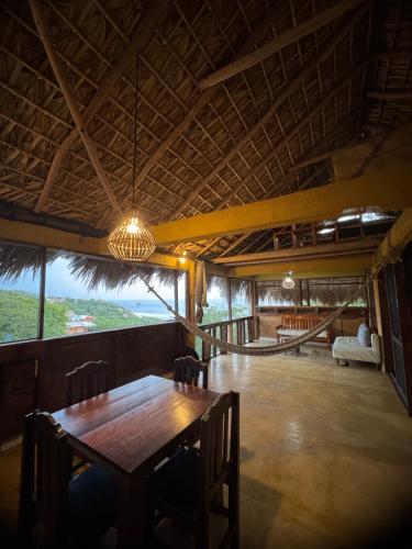 a dining room with a table and chairs and a view at Cabaña con vista al mar y wifi Starlink en San Agustinillo in San Agustinillo