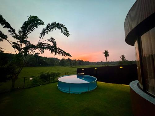 a backyard with a circular pool in the grass at The Glamp - Homagama in Talagala