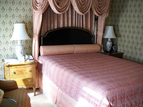 a bedroom with a bed with a canopy and two lamps at Hotel Majestic in San Francisco