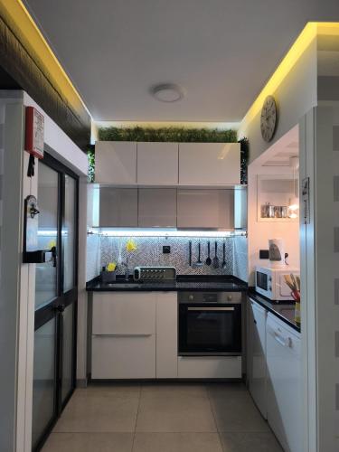 a kitchen with white cabinets and a stove top oven at Aromas do Vouga in São Pedro do Sul