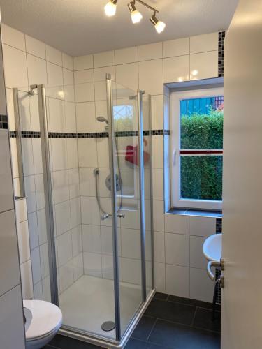 Un baño con ducha, inodoro y ventana. en Sternenhimmel, en Wangerland