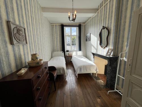 a bedroom with a bed and a desk and a fireplace at La Fumacienne in Fumay