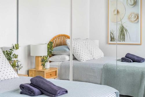 two beds in a room with purple pillows on them at 803 - Stylish Retreat - Ocean Views & Parking in Newcastle