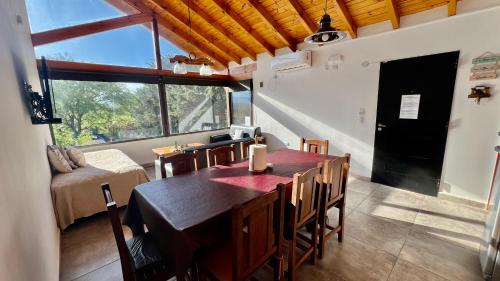 a dining room with a table and chairs and a window at Fincas del Faldeo in Villa General Belgrano