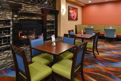 uma sala de jantar com mesas e cadeiras e uma lareira em Holiday Inn Express Flagstaff by IHG em Flagstaff