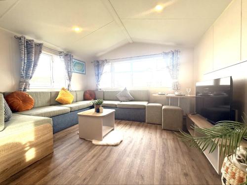 a living room with a couch and a table at Grand Horizon in Hunmanby