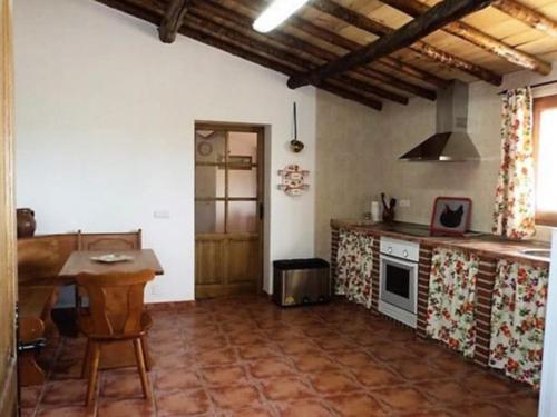 a kitchen with a table and a stove top oven at La huerta El Tordo in Manganeses de la Lampreana