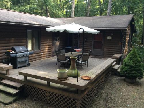a wooden deck with a table and an umbrella at The Bunkhouse in Perrysville