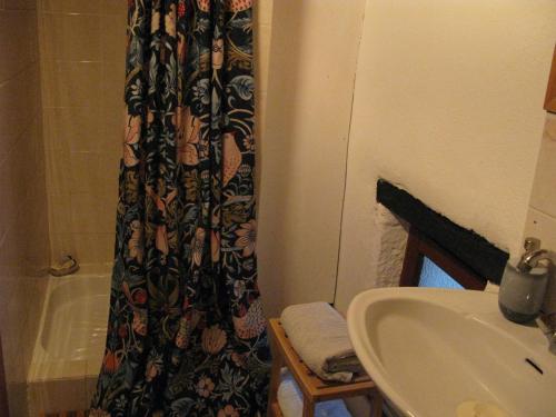 a bathroom with a sink and a shower curtain at Romantic Cottage Retreat for Two in South Vienne in Champniers