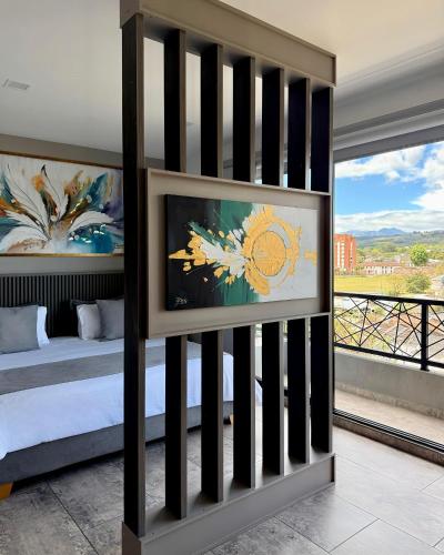a bedroom with a bed and a balcony with a view at M A Hotel in Popayan
